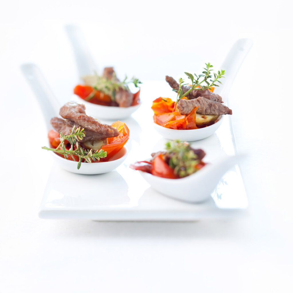 packshot produit sur fond blanc, de morceaux de viandes sur des cuilleres et du thym