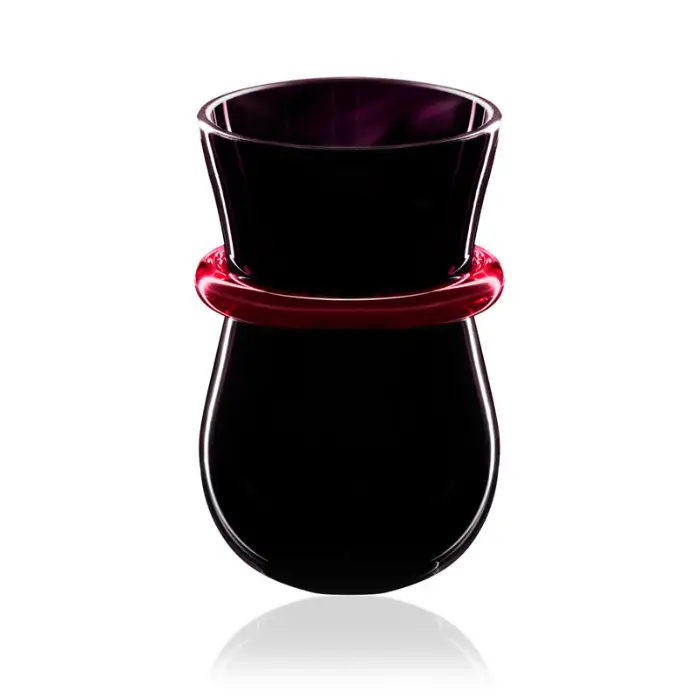 Packshot studio d'un verre design en verre noir et bague rouge vif sur fond blanc, photographie publicitaire d'art de la table dans la Drôme.